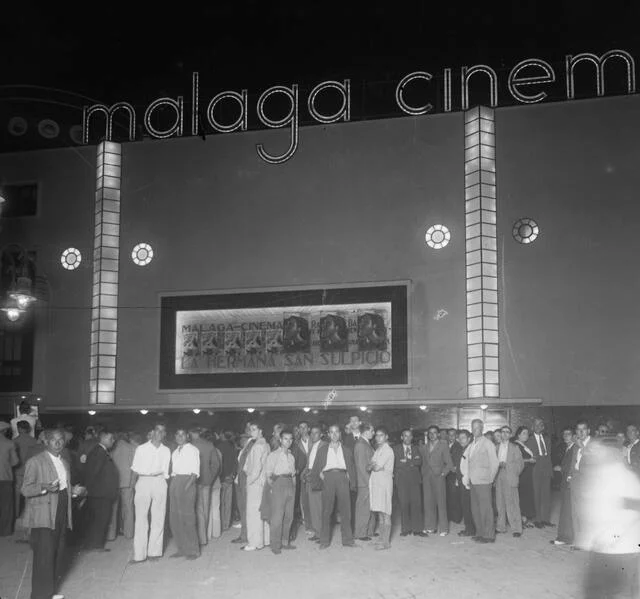 Fachada nocturna del Málaga Cinema, con público ante la entrada y cartel de La hermana San Sulpicio.